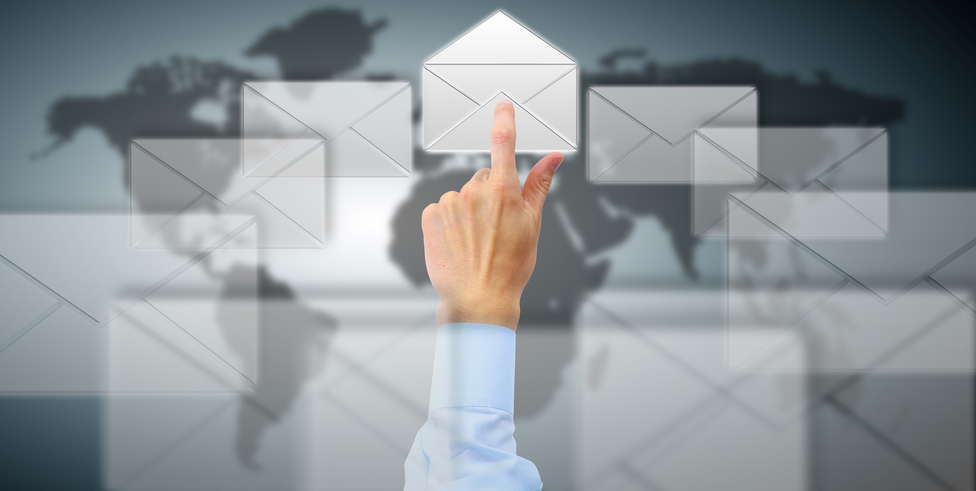 many envelopes over a world map with a hand reaching out with a pointer finger tapping one open envelope
